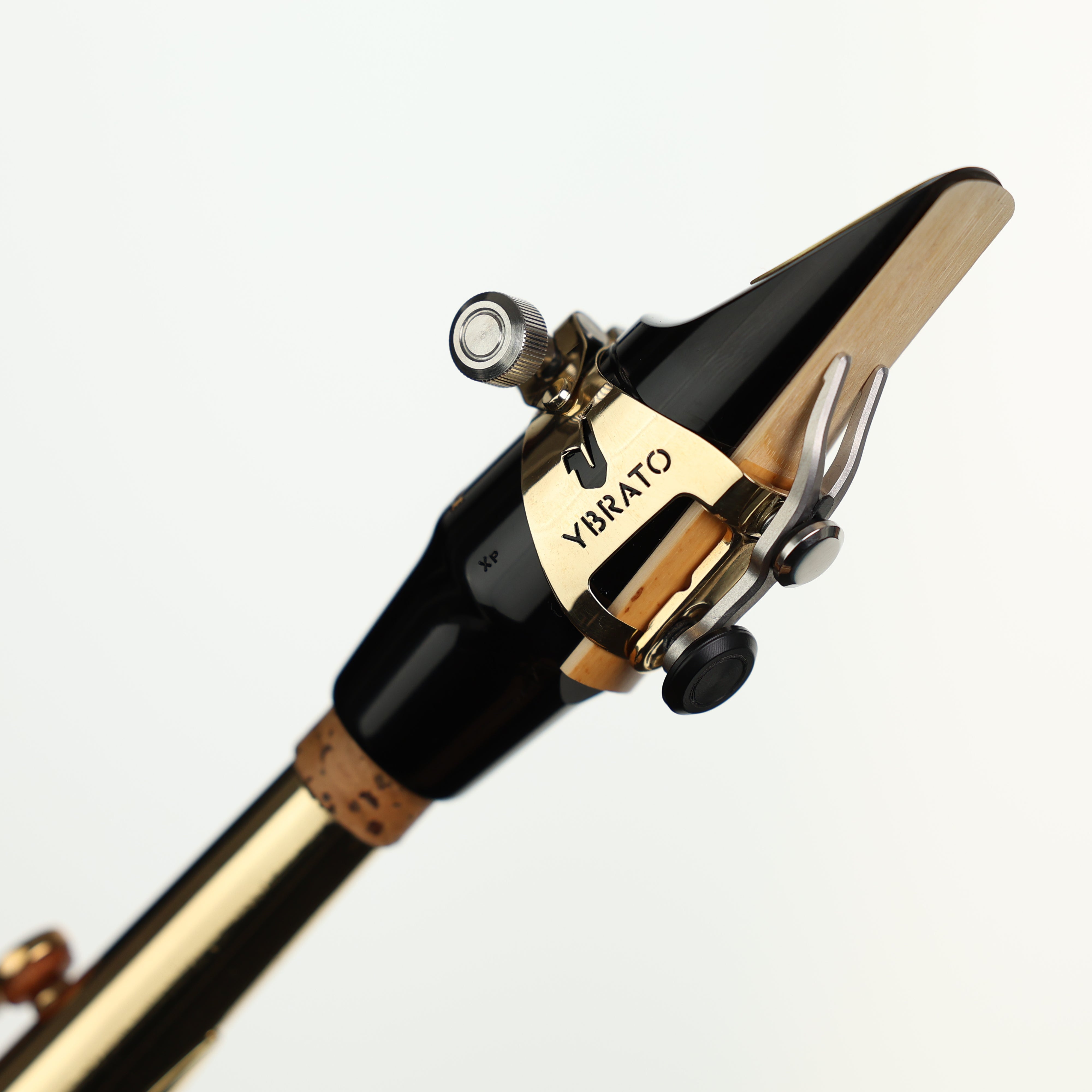 Ybrato SweetSpot Ligature attached to a saxophone mouthpiece on an instrument, highlighting the reed and ligature setup