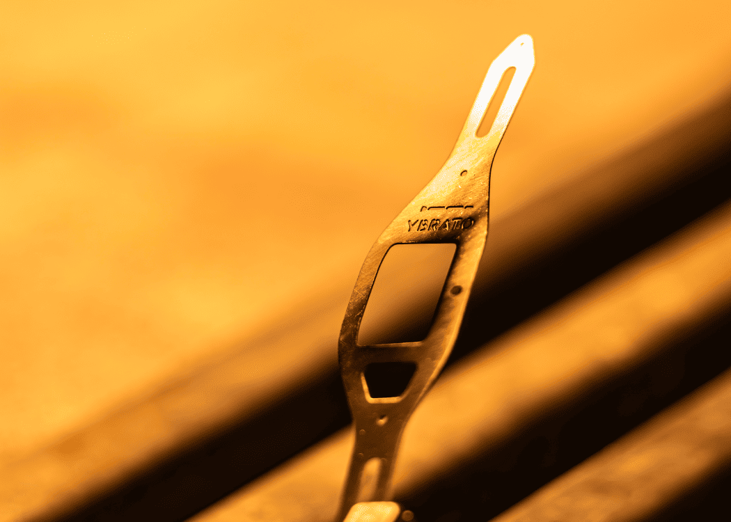 Detailed view of a golden YBRATO ligature part during the manufacturing process. The intricate pattern highlights the German engineering and innovative design for saxophone and clarinet mouthpieces.